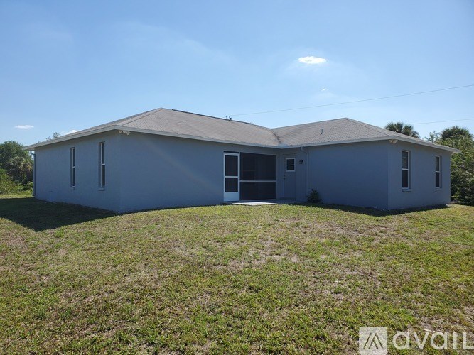 A grey house with a brown roof and a white door.