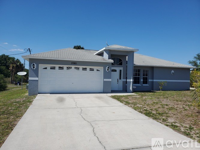A two-story house with a garage and a driveway in front.