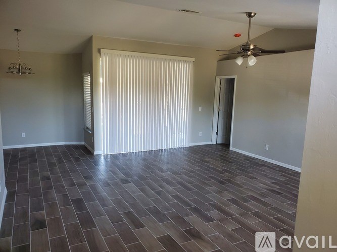 A room with a ceiling fan and a door leading to another room.