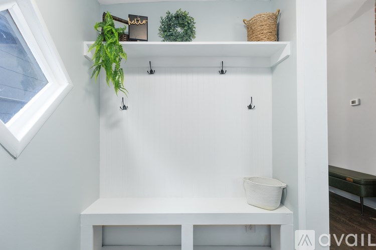 A white shelf with a plant and a basket on it.