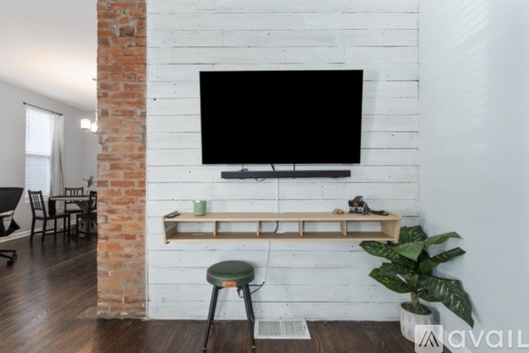 A white brick column with a black screen mounted on it.