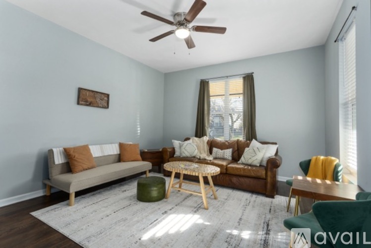 A living room with a brown couch, a green armchair, and a wooden coffee table.