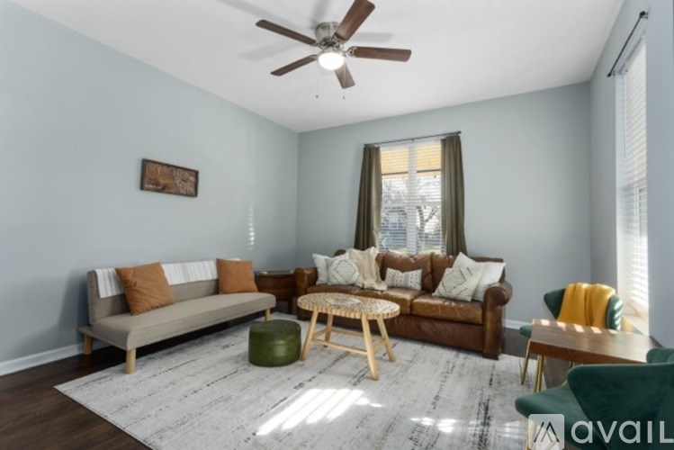 A living room with a brown couch, a green armchair, and a wooden coffee table.