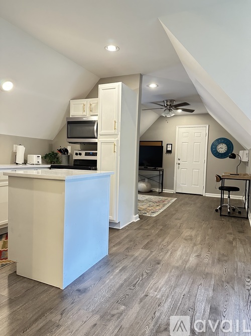 A kitchen with a white island and wooden floors.