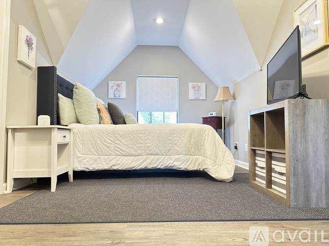 A bedroom with a bed, nightstand, and a television.