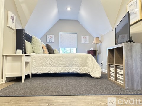 A bedroom with a bed, nightstand, and a television.
