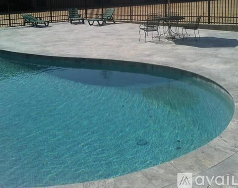 A pool with a table and chairs around it.