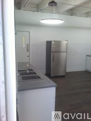 A kitchen with a stainless steel refrigerator and a white counter.