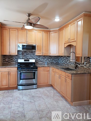 A kitchen with wooden cabinets and a black granite countertop.