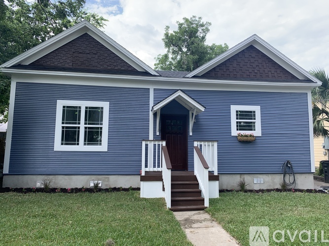 A blue house with a brown door and white windows.