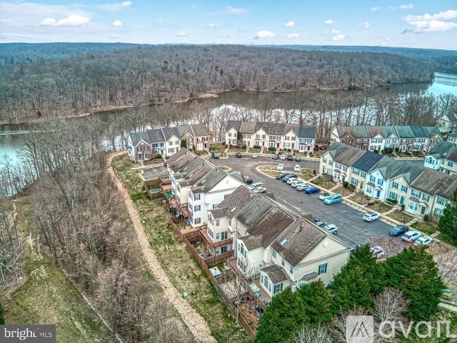 A bird's eye view of a residential area with houses and a lake in the background.