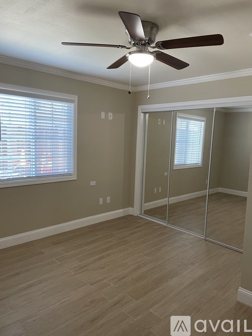 A room with a ceiling fan and a sliding glass door.