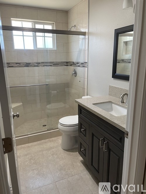 A bathroom with a toilet, sink, and shower.