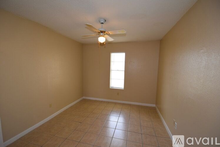 A room with a ceiling fan and a window.