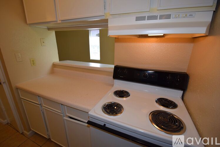 A white stove top oven with four burners is in a kitchen.