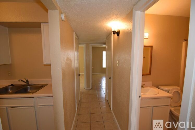 A long hallway with a sink and toilet visible.