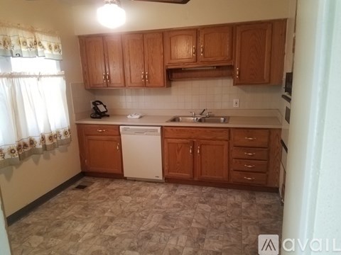 A kitchen with wooden cabinets and a white dishwasher.