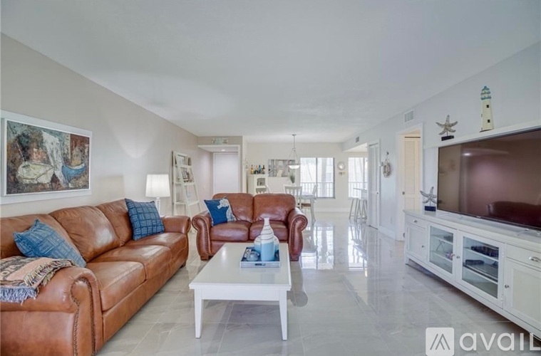 A living room with a brown leather couch and a white coffee table.