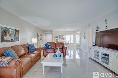 A living room with a brown leather couch and a white coffee table.