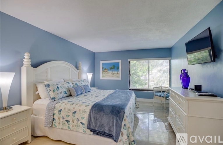 A bedroom with a bed, nightstand, and a painting on the wall.