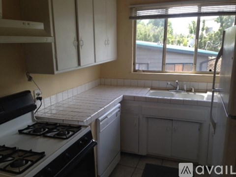 A kitchen with white appliances and cabinets.