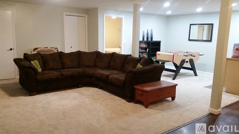 A living room with a brown couch and a wooden coffee table.
