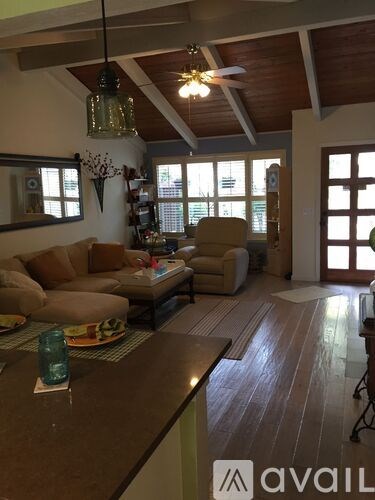 A living room with a brown couch and a wooden floor.