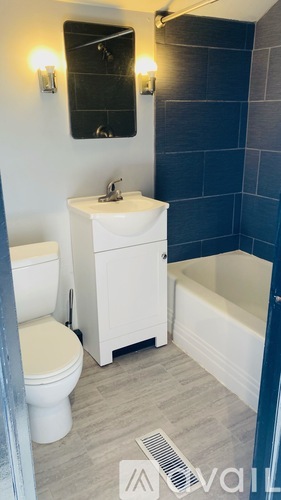 A white sink and toilet in a bathroom with blue tiles.