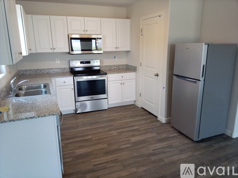 A kitchen with white cabinets and a granite countertop.