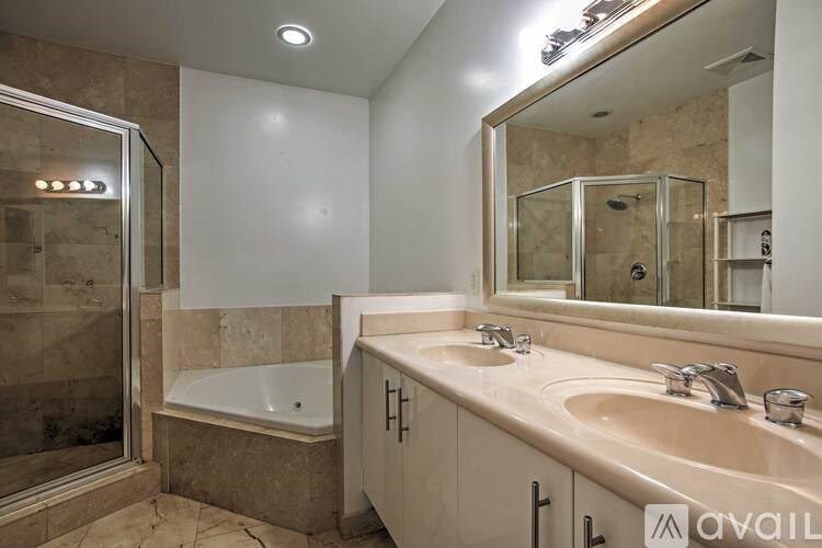 A bathroom with a tub, sink, and mirror.