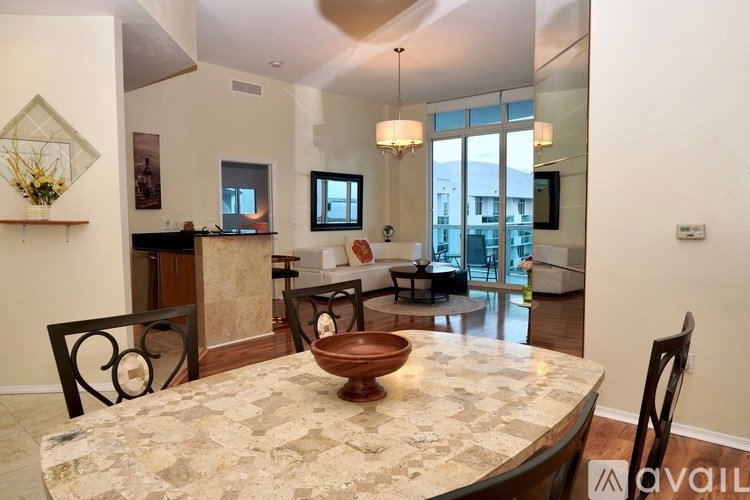 A modern dining room with a marble table and chairs.