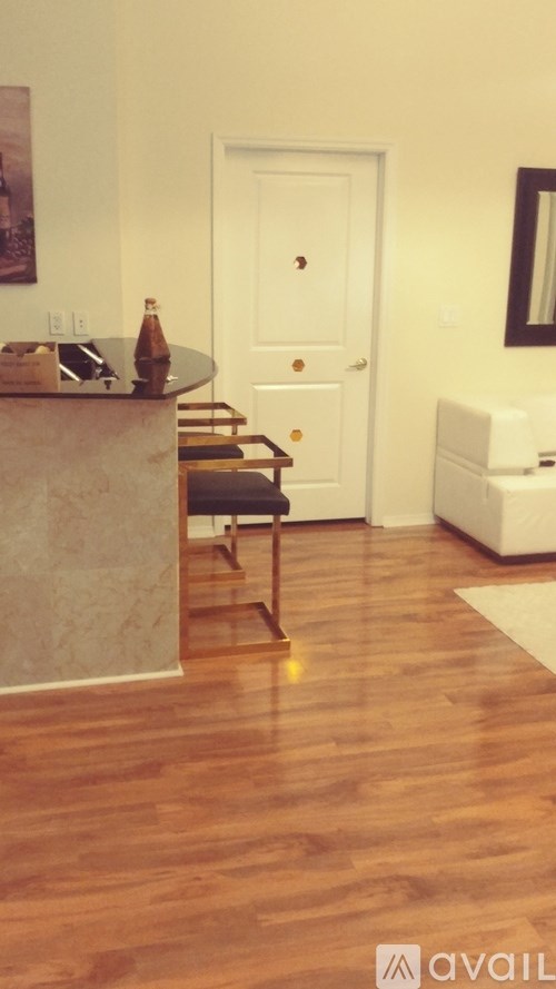 A kitchen with a wooden floor and a white door.