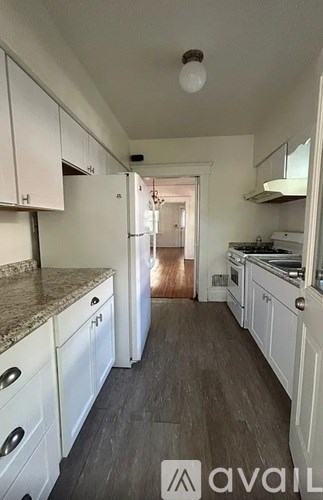 A kitchen with white cabinets and a marble countertop.