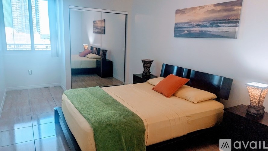 A bedroom with a large bed and a painting on the wall.