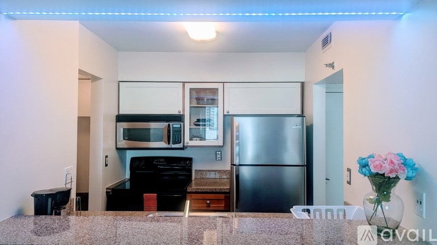 A kitchen with a black stove top oven and a refrigerator.