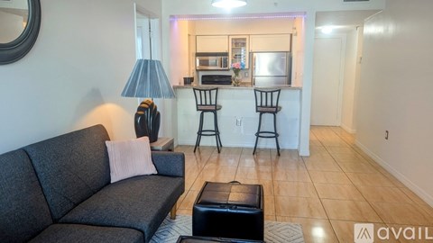 A living room with a grey sofa and a black ottoman.