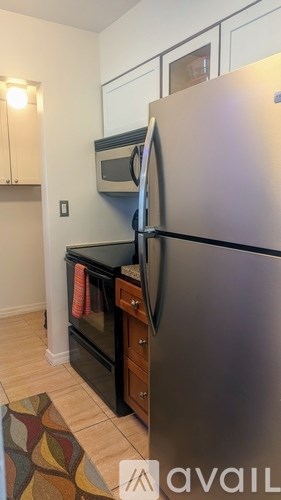 A kitchen with a refrigerator, oven, and microwave.