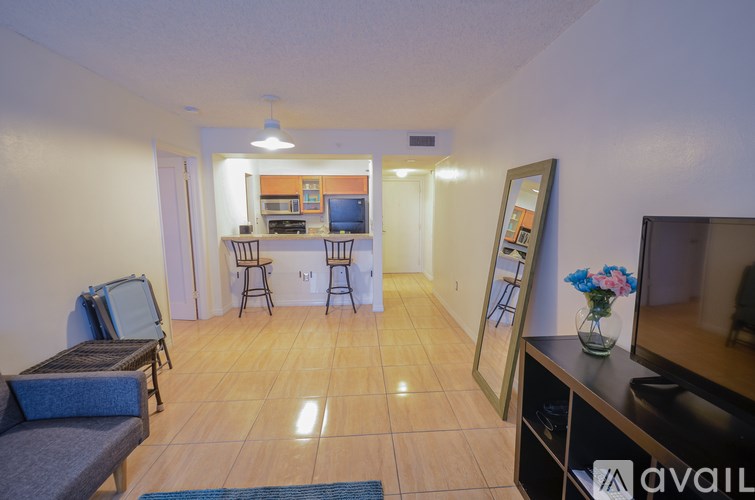 A living room with a couch, chairs, and a television.