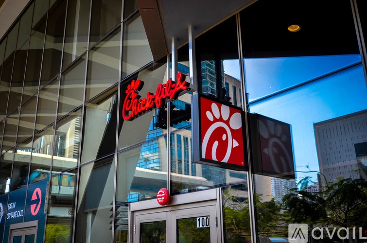 A Chick-fil-A sign is reflected in the window of a building.