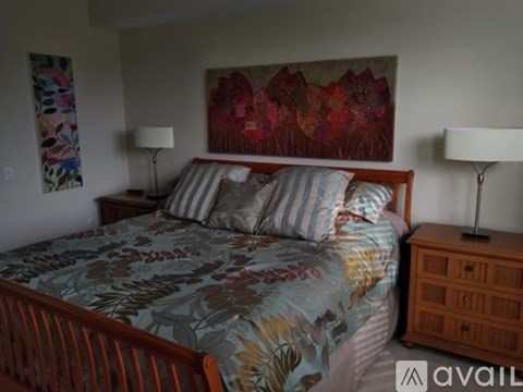 A bedroom with a bed, nightstand, and lamp.