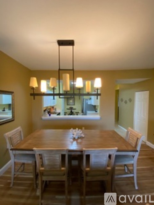 A dining room with a wooden table and chairs.