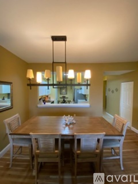 A dining room with a wooden table and chairs.