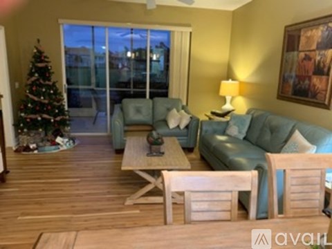 A living room with a Christmas tree and a couch.