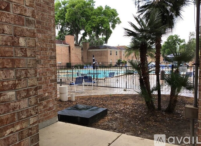 A pool surrounded by a fence and trees.