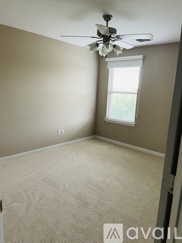 A room with a fan and a window.
