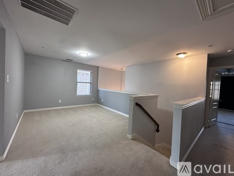 A spacious room with a carpeted floor and a window.