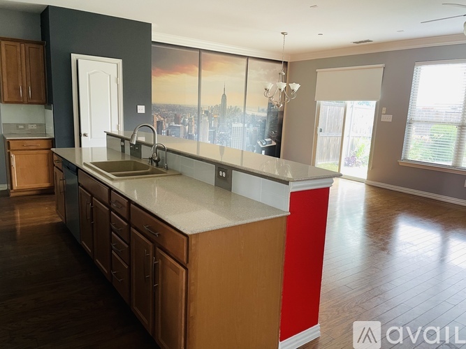 A kitchen with wooden cabinets and a large island with a sink.
