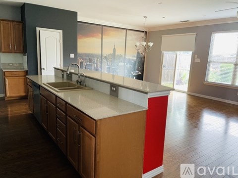 A kitchen with wooden cabinets and a large island with a sink.