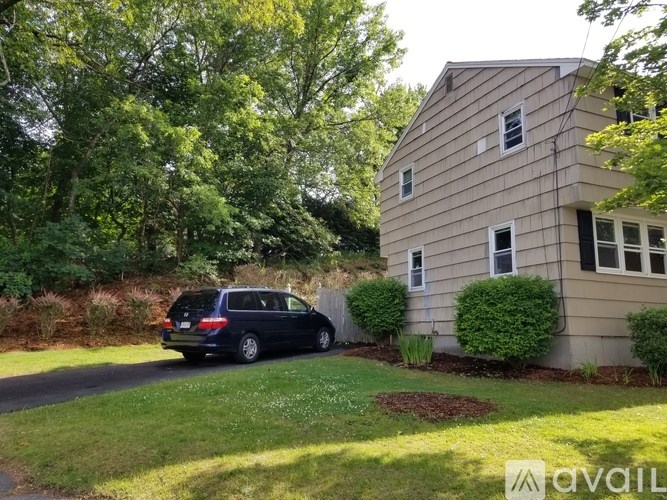 A house with a blue car parked in front of it.