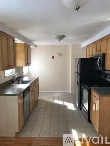 A kitchen with wooden cabinets and black appliances.